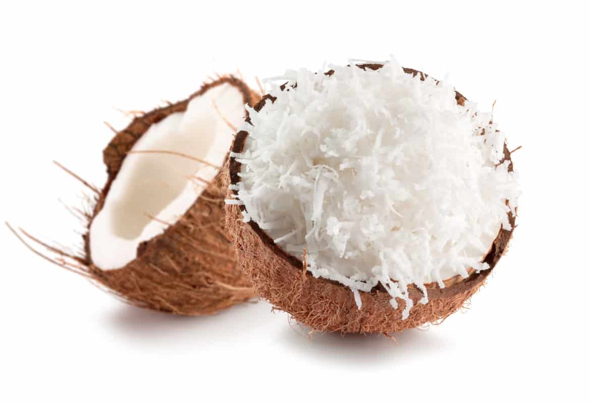 Two coconut halves one containing grated coconut