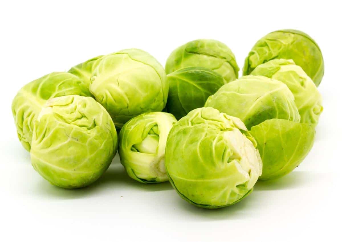 A bunch of Brussels sprouts placed on a plain surface