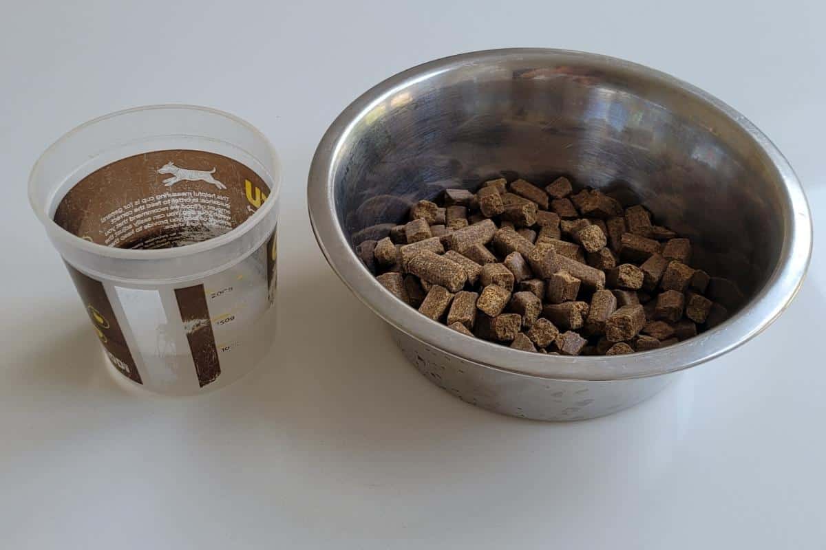 A bowl of dry dog food and a quarter of a cup of water to add.